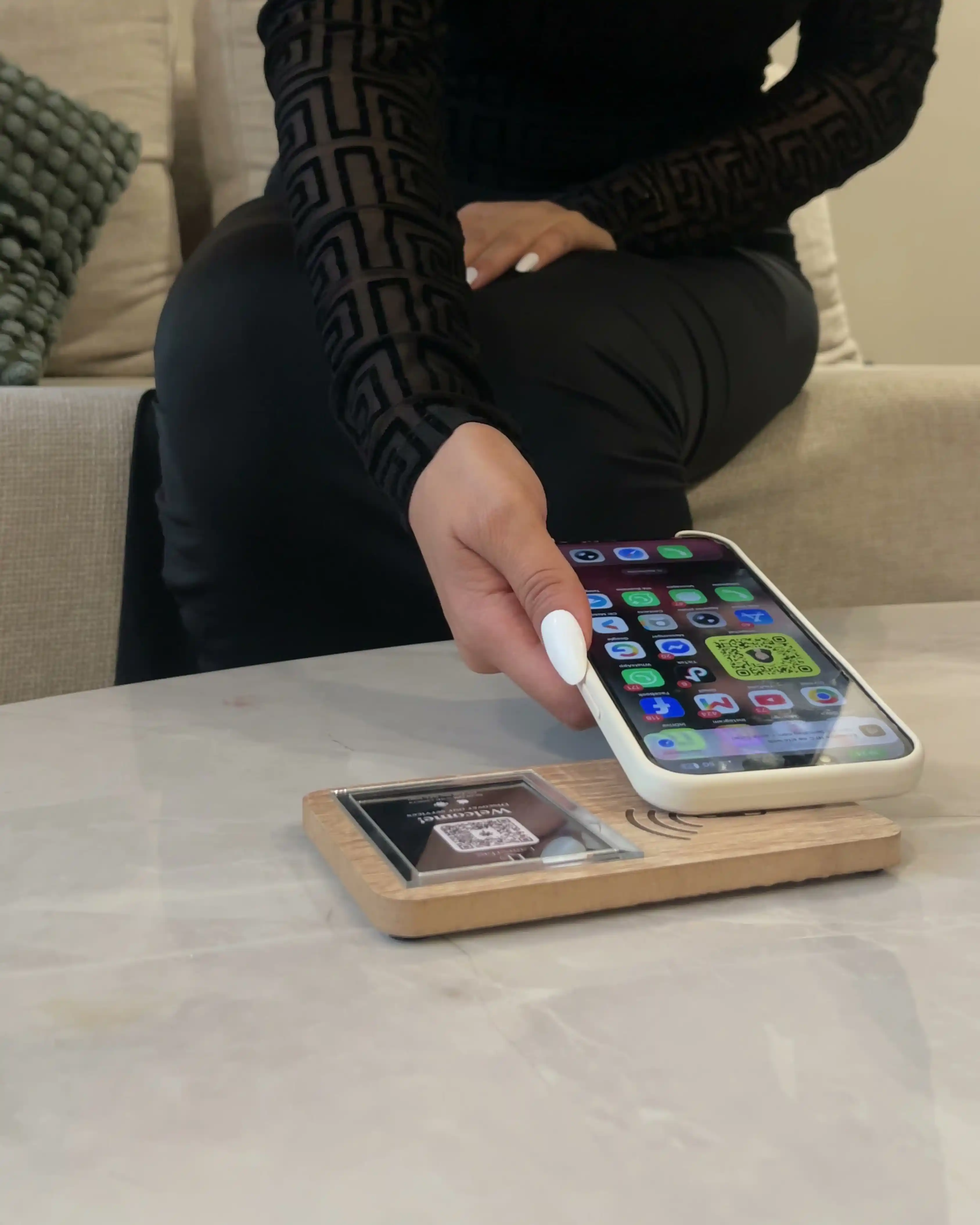 Client touchant une plaque NFC LamsaTag avec son smartphone dans un restaurant au Maroc